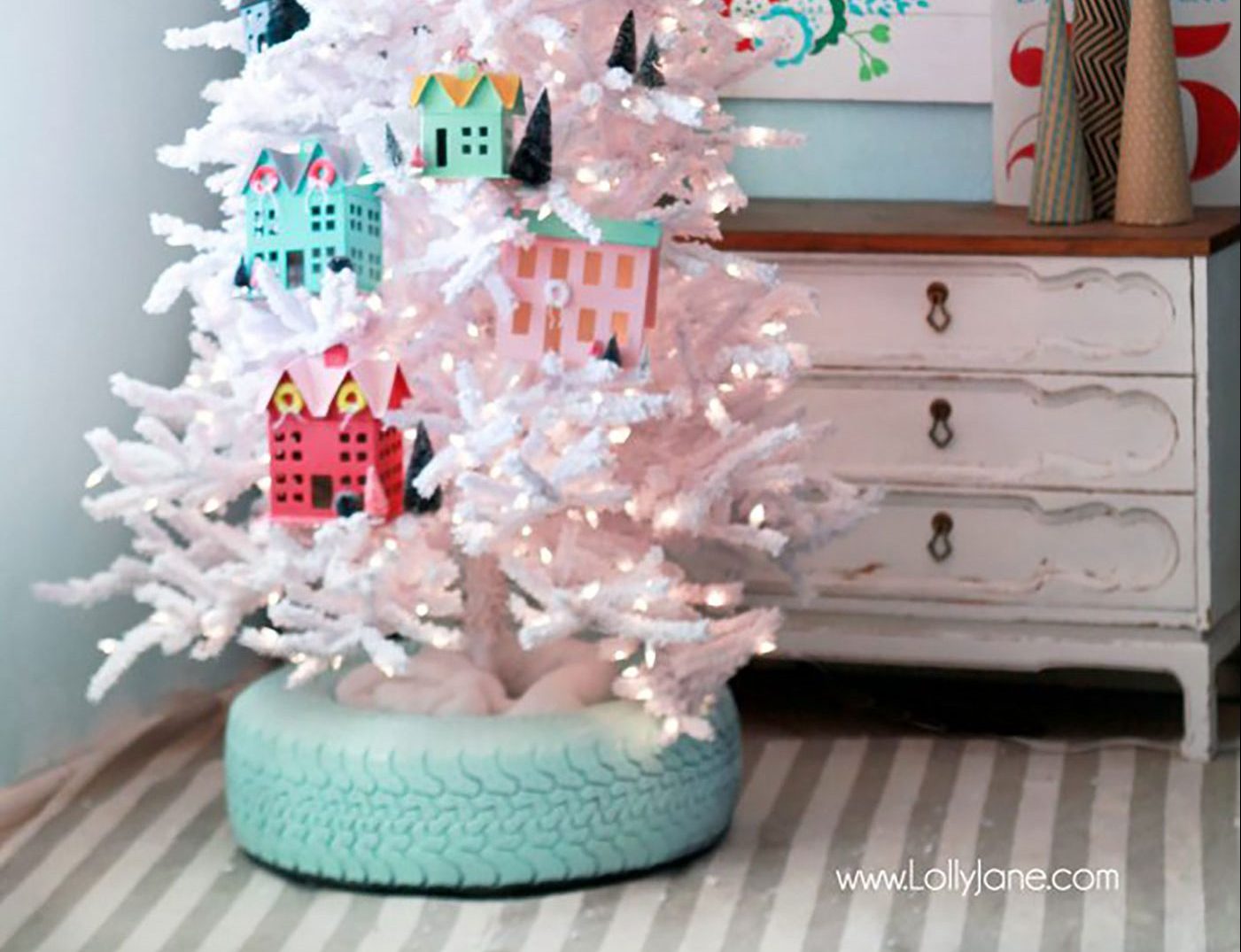 A Christmas tree stand cover in the shape of a turquoise-painted tire.